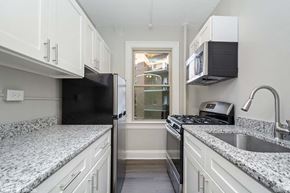 Washington apartment for rent - a kitchen with white cabinets and a window