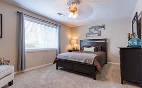 Fairburn apartment for rent - A bedroom with a bed, dresser, and window.
