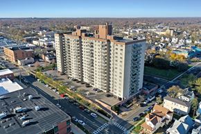 Asbury Park apartment for rent - A large building with a parking lot in front of it.