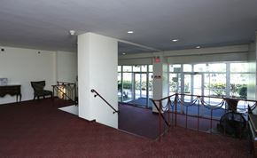Trenton apartment for rent - A large room with a red carpet and a staircase.