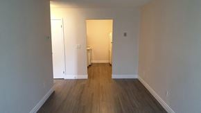 Oshawa apartment for rent - an empty living room with wood floors and white walls