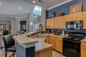 Dallas apartment for rent - A kitchen with wooden cabinets and a black stove top oven.
