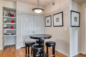 Dallas apartment for rent - a dining room with a table and three stools in front of a white door