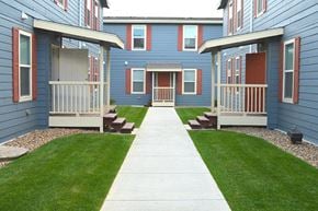 Watford City apartment for rent - a sidewalk in front of a row of blue houses