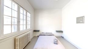 Ottawa apartment for rent - a bedroom with a bed and a radiator and large windows