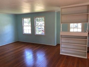 Talladega house for rent - an empty room with blue walls and a wooden floor