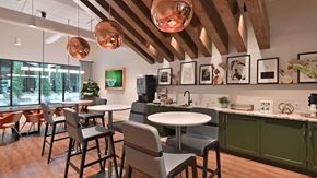 Mckinney apartment for rent - High top café tables site in front of a full coffee bar along the back wall. Large copper light fixtures hang from the ceiling.