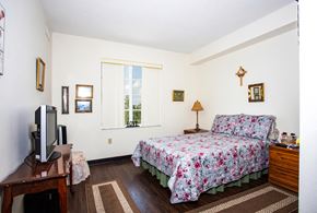 Fort Myers apartment for rent - bedroom with large window, hardwood-style flooring, and model furnishings