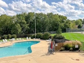 Saints Charles townhouse for rent - a swimming pool with chairs around it next to a lawn