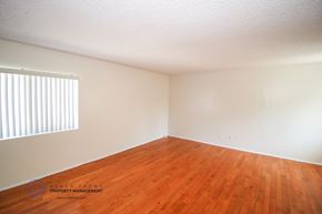 Torrance apartment for rent - a bedroom with wood floors and white walls and a window