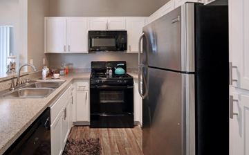 Santa Clarita apartment for rent - A modern kitchen with a black refrigerator and stove.