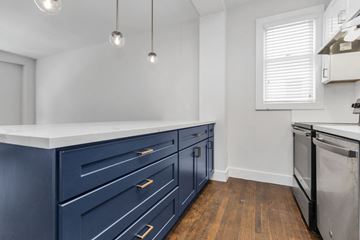 San Francisco apartment for rent - A kitchen with dark blue cabinets and a stainless steel dishwasher.