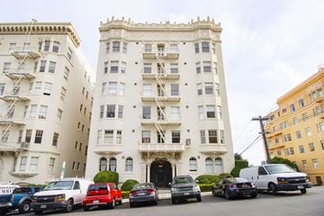 San Francisco apartment for rent - A row of cars are parked in front of a white building.
