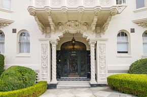 San Francisco apartment for rent - A white building with a black door and a decorative archway above it.