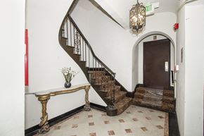 San Francisco apartment for rent - A staircase with a metal railing and a brown carpeted landing.
