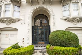 San Francisco apartment for rent - A large, ornate entrance to a building with a black door and a sign on the wall.