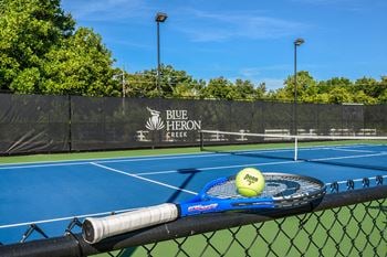 Lighted tennis court with shaded seating