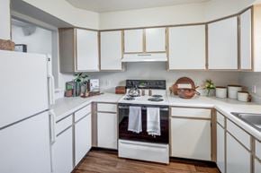 Toledo townhouse for rent - a kitchen with white cabinets and a stove and a refrigerator