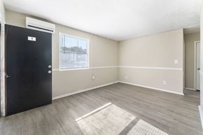 Jacksonville apartment for rent - an empty living room with a black door and a window