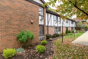Canton apartment for rent - exterior view of a brick apartment building with a sidewalk and landscaping