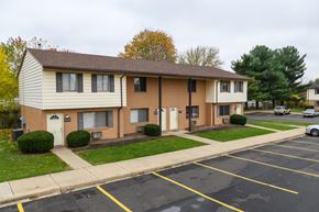 Canton apartment for rent - a tan and white apartment building with a parking lot