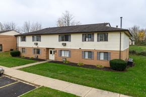 Canton apartment for rent - a white and brick house with green grass and a sidewalk