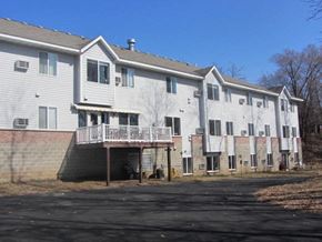 Hudson apartment for rent - a white building with a balcony and a parking lot