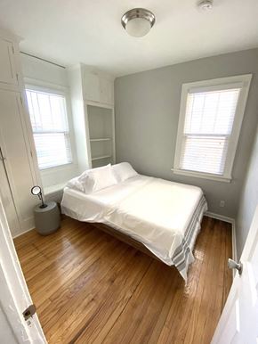 Detroit apartment for rent - a small bedroom with a bed and a wood floor