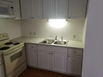 Wadsworth apartment for rent - A kitchen with white cabinets and a stove top oven.