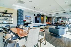 Frisco apartment for rent - Resident lounge area with bar top seating, catering kitchen, lounge seating, entertainment area, and rooftop pool access