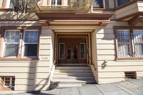 San Francisco apartment for rent - A beige building with a brown door and windows.