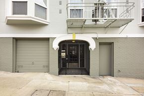 San Francisco apartment for rent - A building with a black gate and a balcony with a metal railing.