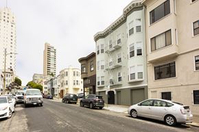 San Francisco apartment for rent - A street with cars parked on the side and buildings in the background.