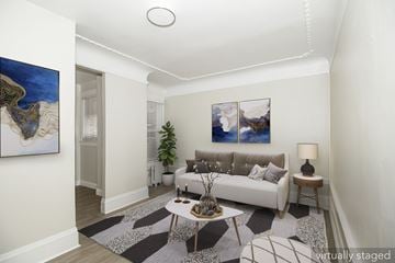 San Francisco apartment for rent - A living room with a white couch, a coffee table, and two paintings on the wall.