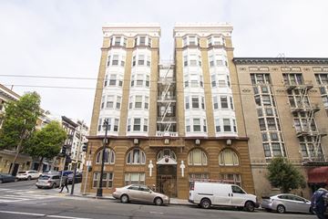 San Francisco apartment for rent - A brown building with a cross on the front and a white van parked in front.