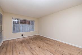 Oakland apartment for rent - Empty room with wooden flooring and a window.