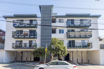 Oakland apartment for rent - A white car is parked in front of a modern apartment building.