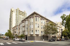 San Francisco apartment for rent - A street view of a building with cars parked in front.