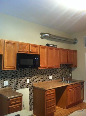 Chicago apartment for rent - a kitchen with wooden cabinets and a black microwave
