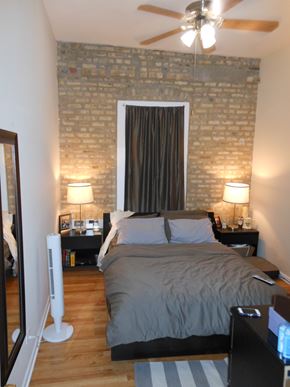 Chicago apartment for rent - a bedroom with a bed and a window and a ceiling fan