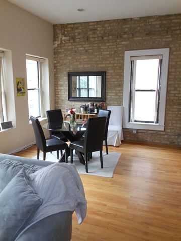Chicago apartment for rent - a view of a living room and dining room with a couch and a table