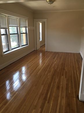 Chicago apartment for rent - an empty living room with wooden floors and windows