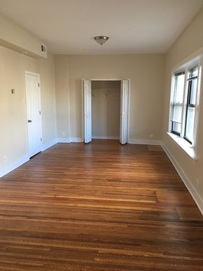 Chicago apartment for rent - an empty living room with wooden floors and a window