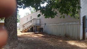 Laurens house for rent - A tree is in the foreground of a photo showing a house with a garage.