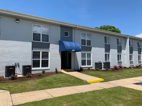Newport News apartment for rent - an apartment building with a blue awning and grass