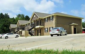 Arkadelphia apartment for rent - A white car is parked in front of a two-story house.