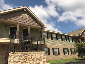 Arkadelphia apartment for rent - A house with a stone wall and a balcony.