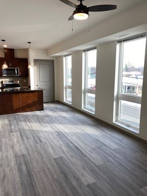 Rochester apartment for rent - A spacious room with a wood floor and a ceiling fan.