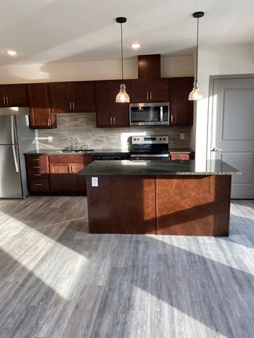 Rochester apartment for rent - A kitchen with a wooden island and pendant lights.