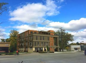 Rochester apartment for rent - A person riding a bicycle in front of a large building.